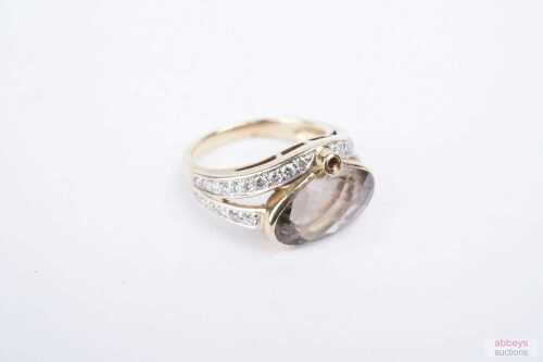 A smoky quartz and diamond ring in 9ct yellow gold.