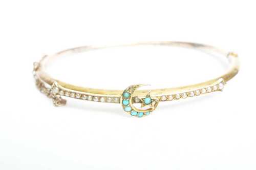 An antique seed pearl and turquoise hinged bangle in 9ct yellow gold