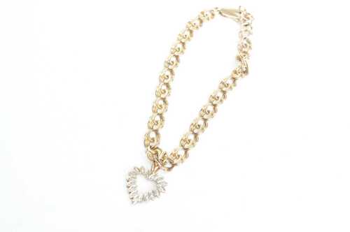 A fancy link bracelet and a diamond heart charm attached in 9ct yellow gold.