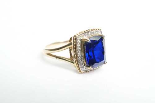 A synthetic sapphire and diamond ring in 9ct yellow gold.