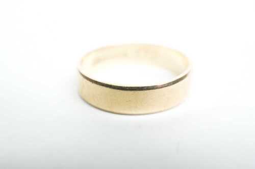 A bevelled edge band in 9ct yellow gold.