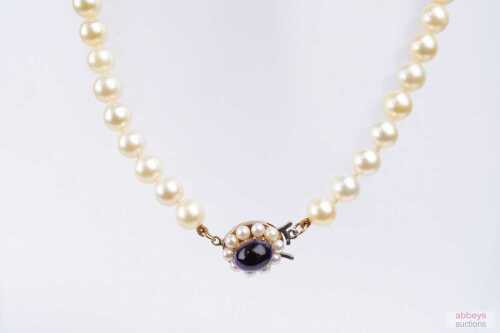 A strand of cultured pearls to a pearl and amethyst set clasp in 9ct yellow gold.