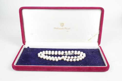 A strand of Mikimoto pearls to a silver clasp in original box.