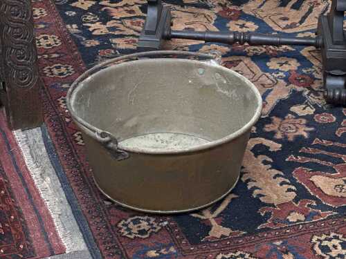 A vintage brass pot with wrought iron handle