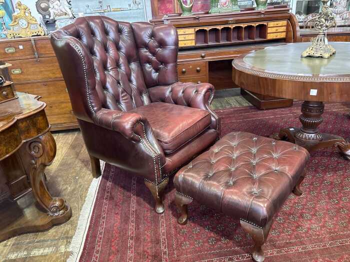 A Gascoigne button back leather wingback armchair & footstool