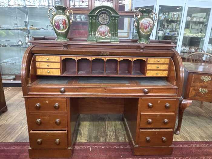 An antique mahogany cylinder roll top desk