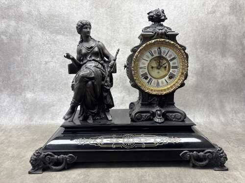 An antique Ansonia cast metal mantel clock with figure of seated lady