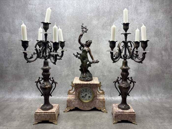 An antique French pink marble clock and garniture set