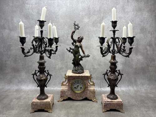 An antique French pink marble clock and garniture set