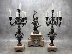 An antique French pink marble clock and garniture set