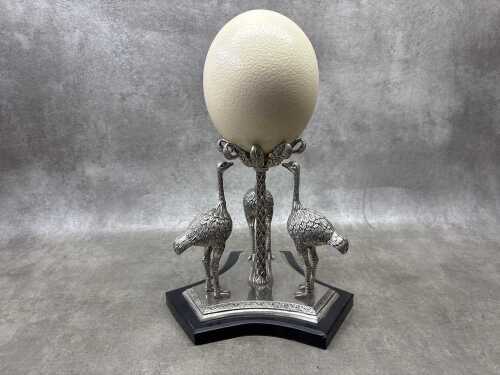 A silver plated centerpiece with three figural ostriches supporting an ostrich egg.