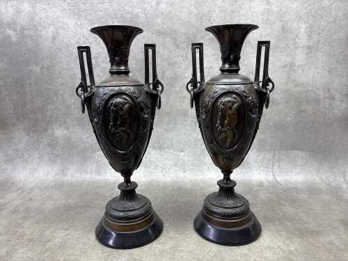 Pair of antique bronze twin handled urns on marble bases