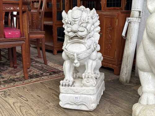 A carved marble foo dog statue