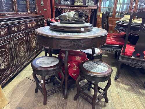 A refined Chinese suite comprising a small circular table and four matching stools.