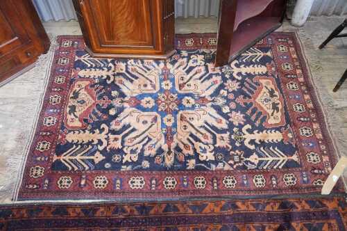 An Afghan Baluch hand knotted wool rug in brown, blue and black tones